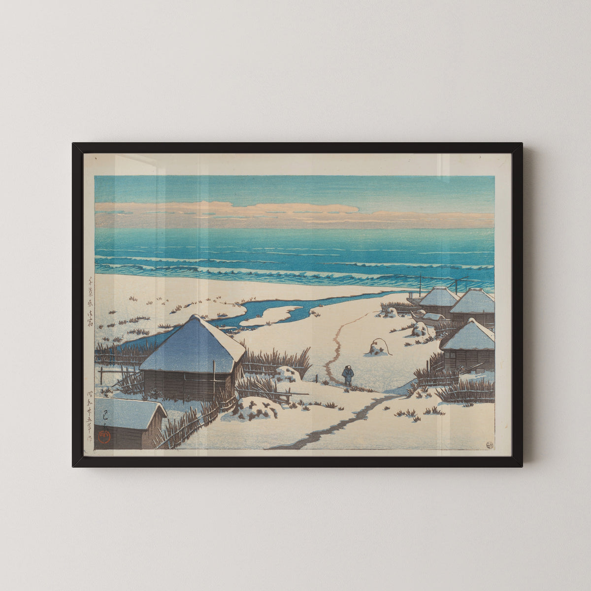 Framed art print of Onjuku, Chiba Prefecture by Kawase Hasui, in a black frame on a pale wall