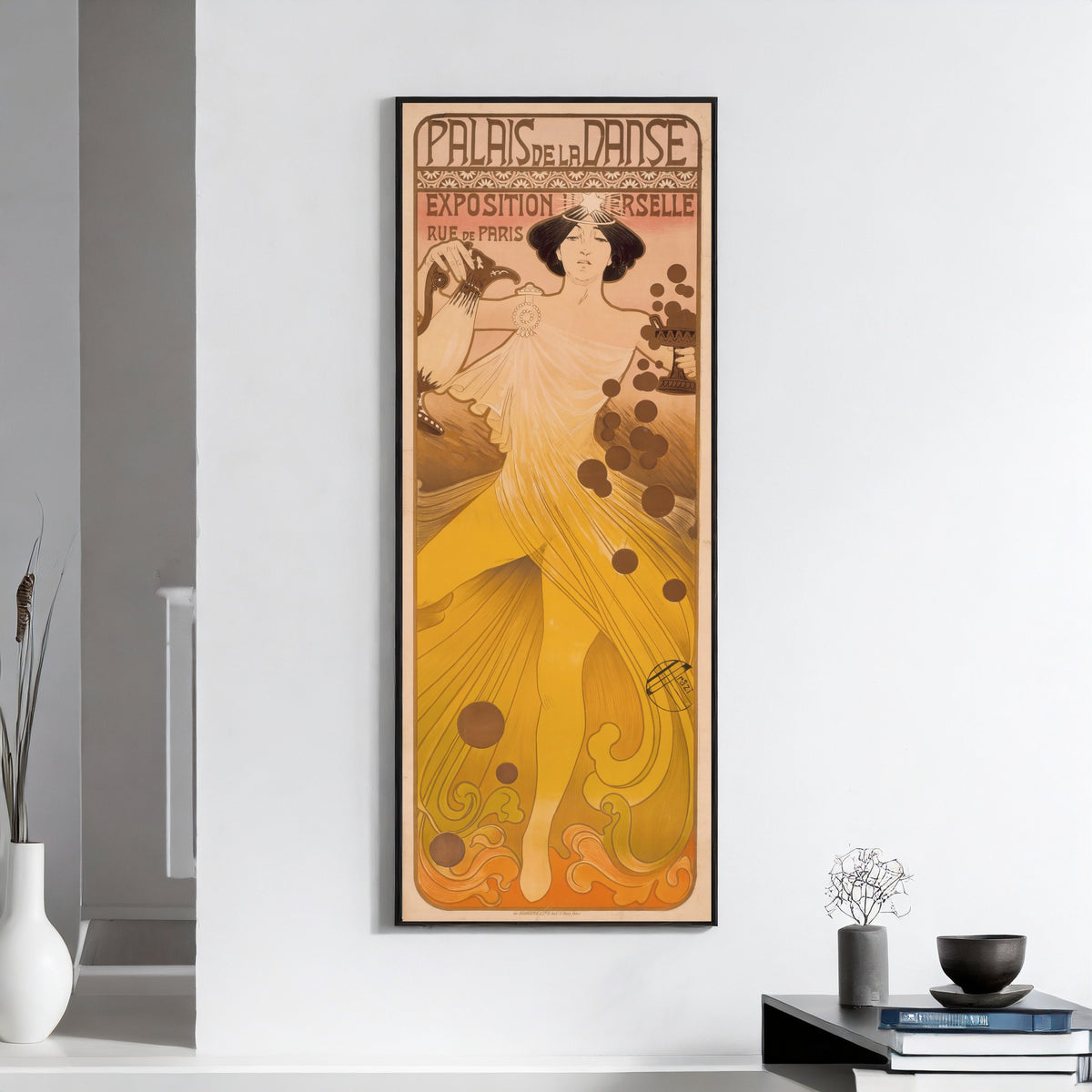 Framed art print of Palais de la Danse, Exposition Universelle by Manuel Orazi, on a white wall above books and a bowl