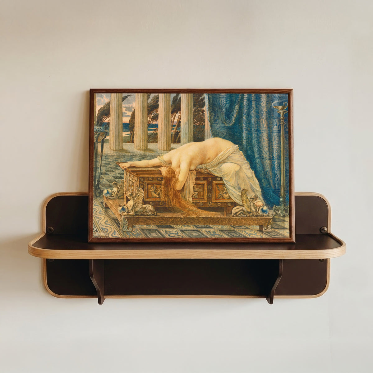 Framed art print of Pandora by Walter Crane, in a dark wood frame resting on a wall shelf