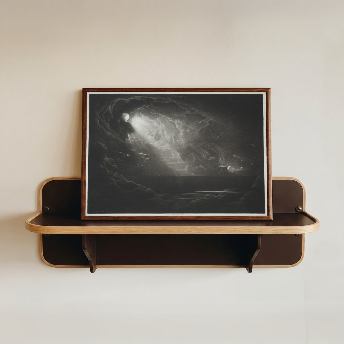 Framed art print of Paradise Lost: The Creation of Light by John Martin, in a dark wood frame resting on a wall shelf