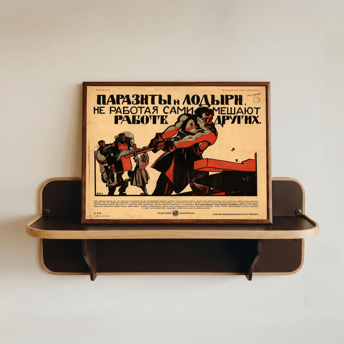 Framed art print of Parasites and Idlers, by Not Working, Themselves Hinder the Work of… by Vasily Kostyanitsyn, in a dark wood frame resting on a wall shelf