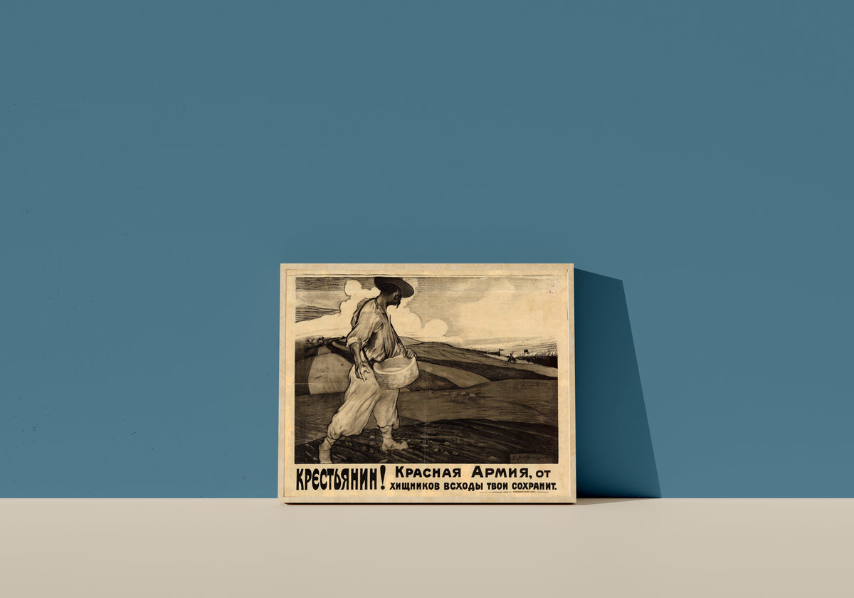 Framed art print of Peasant! The Red Army will protect your crops from the predators by Vasily Kostyanitsyn, in a light wood frame leaning on a blue wall
