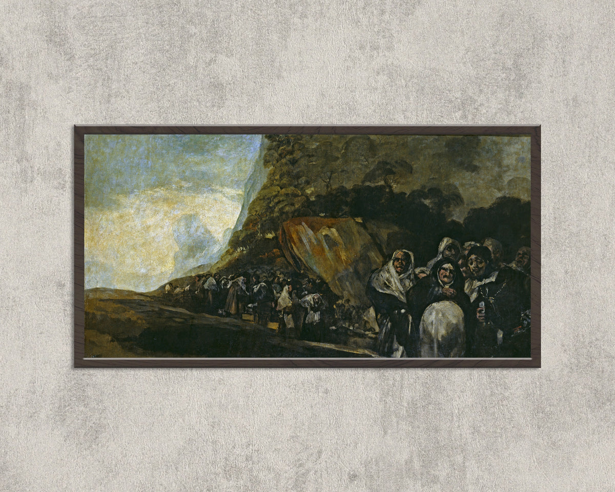 Framed art print of Pilgrimage to the Fountain of San Isidro by Francisco de Goya, in a wide black frame on a concrete wall