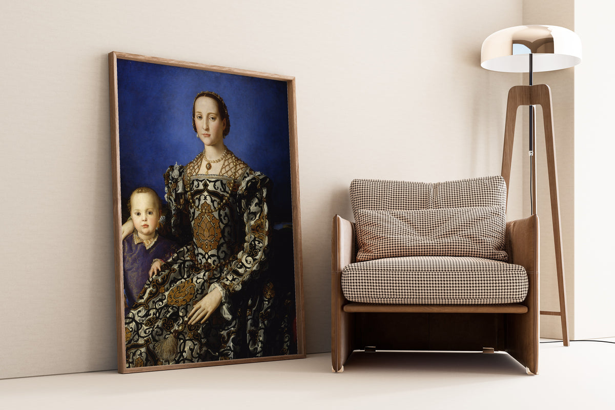 Framed art print of Portrait of Eleanor of Toledo with Her Son Giovanni de’ Medici by Bronzino, leaning against a wall beside an armchair and a floor lamp