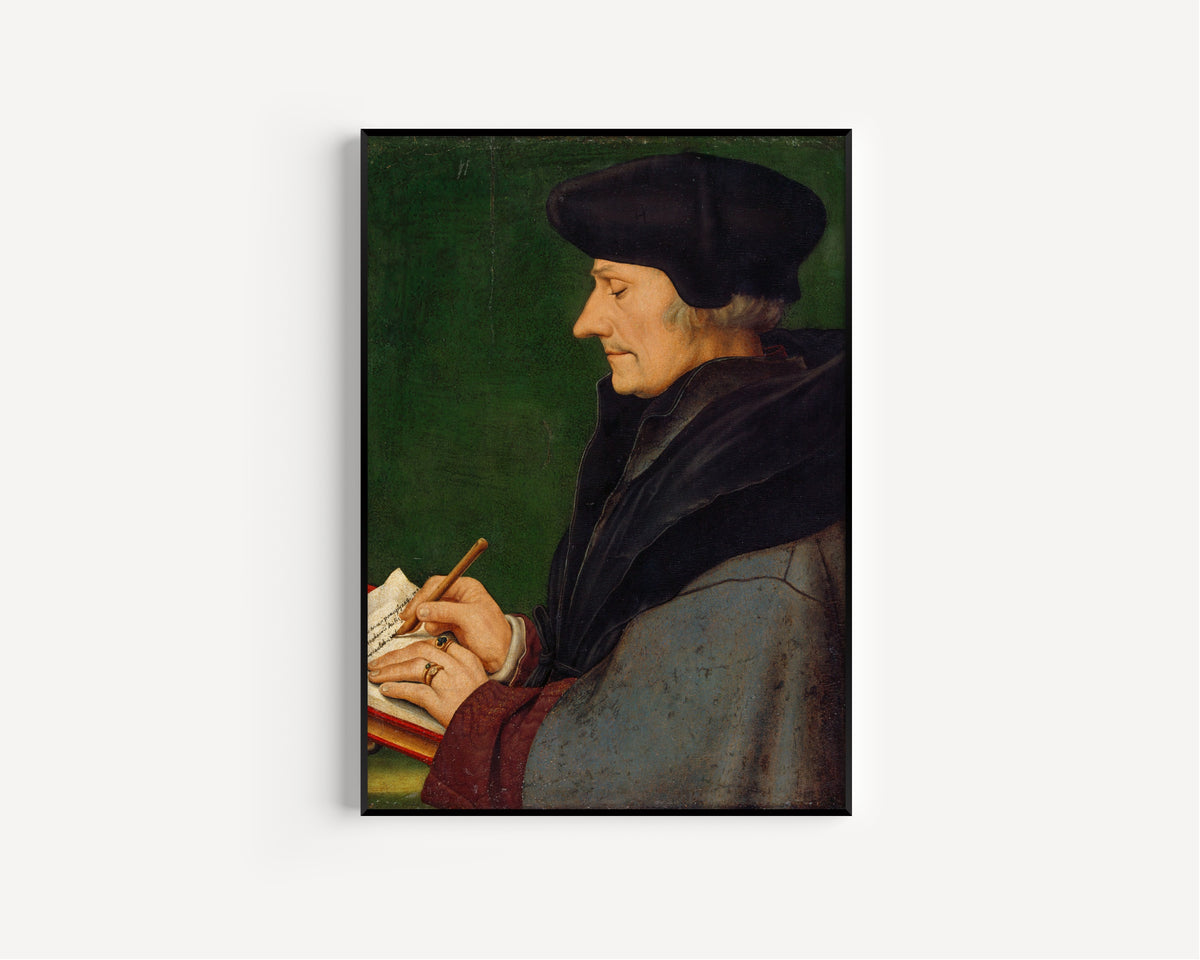 Framed art print of Portrait of Erasmus of Rotterdam Writing by Hans Holbein the Younger, in a slim black frame on a plain white wall