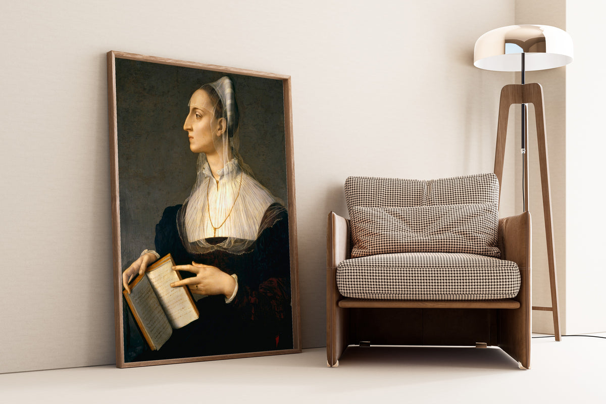 Framed art print of Portrait of Laura Battiferri by Bronzino, leaning against a wall beside an armchair and a floor lamp