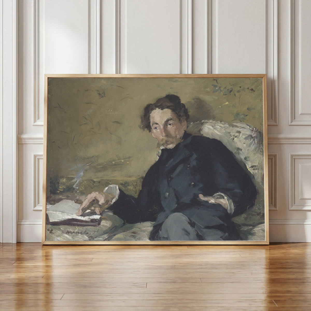 Framed art print of Portrait of Stéphane Mallarmé by Édouard Manet, in a light wood frame leaning against a panelled white wall