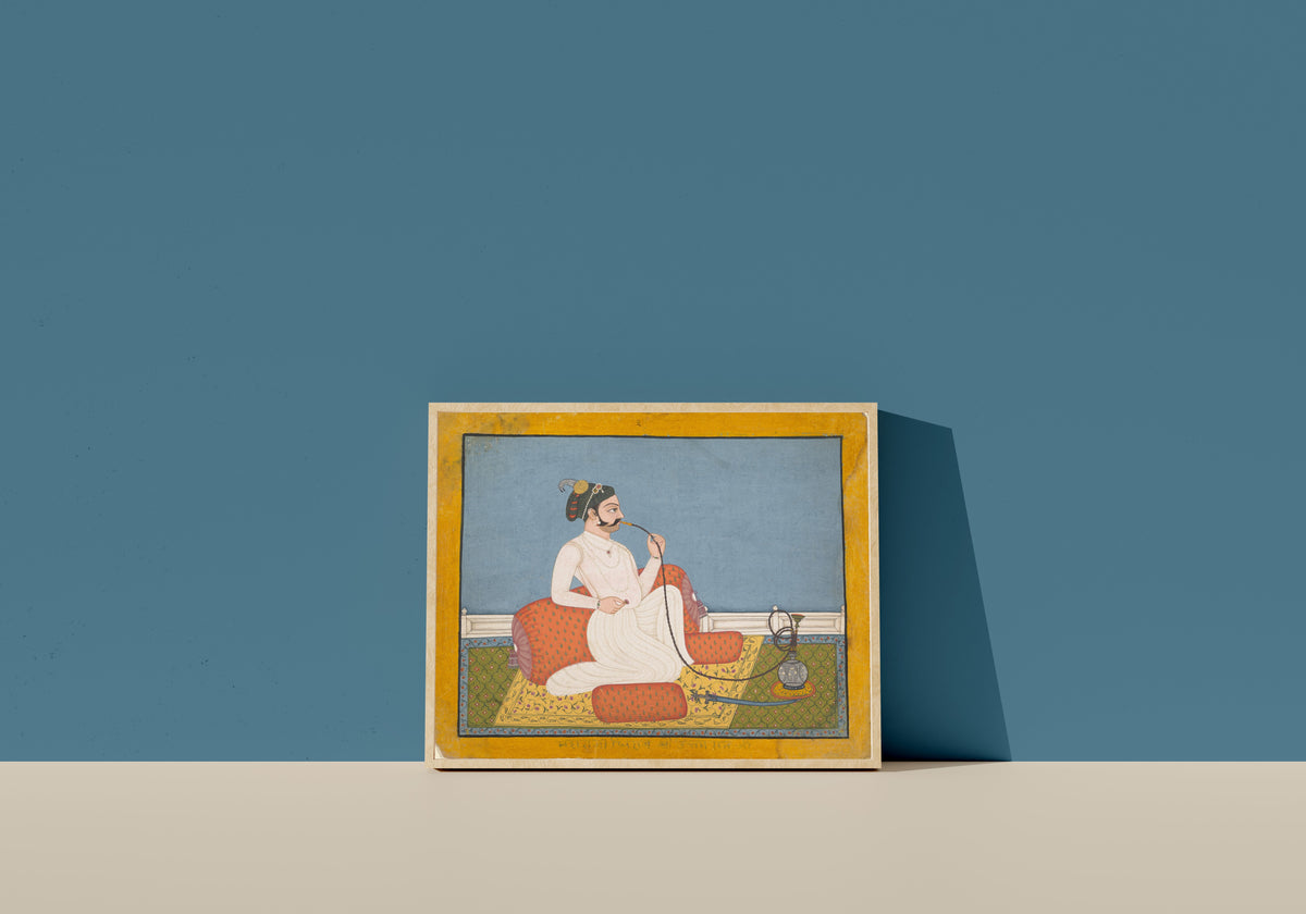 Framed art print of Portrait of Thakur Utham Ram by Jhilai school, in a light wood frame leaning on a blue wall