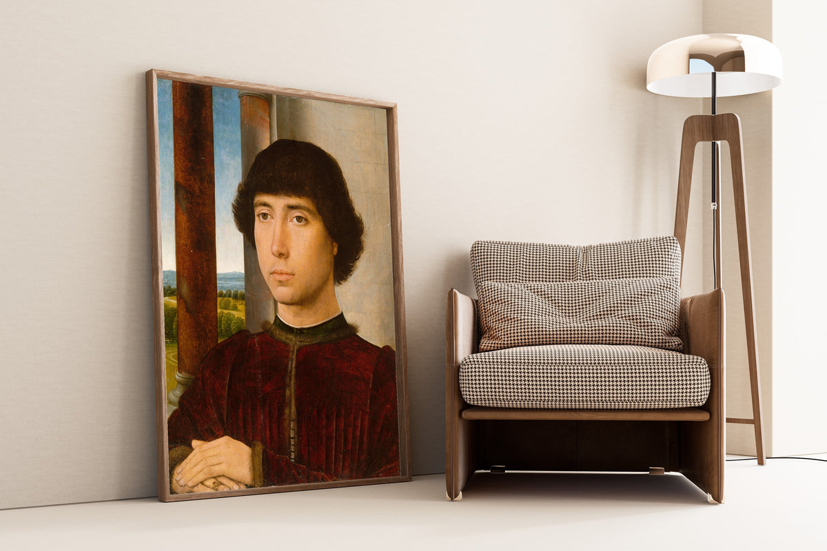 Framed art print of Portrait of a Young Man by Hans Memling, leaning against a wall beside an armchair and a floor lamp