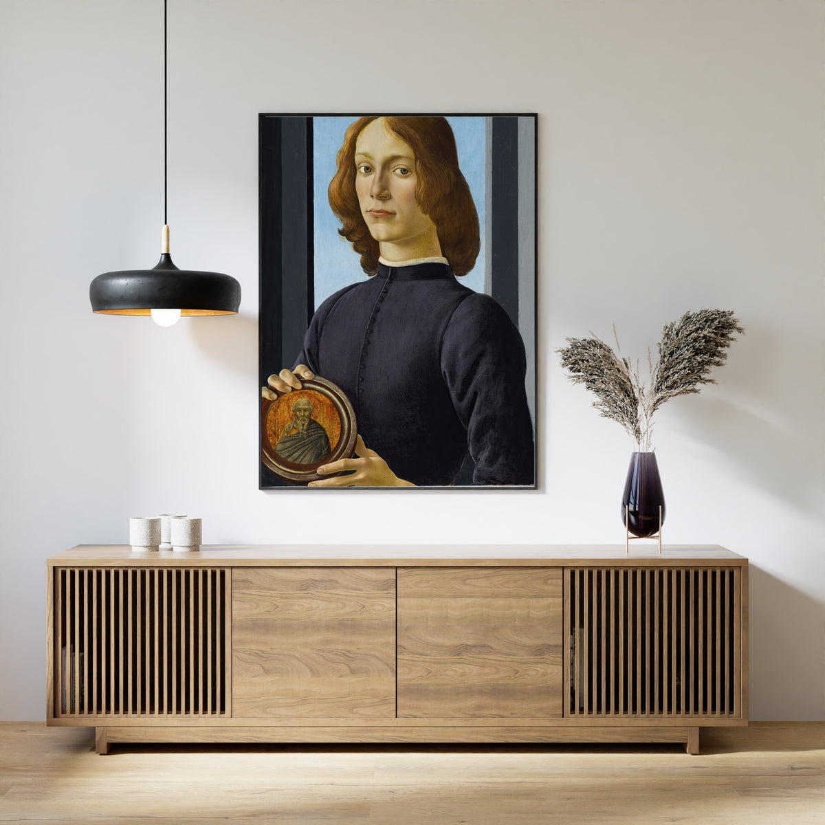 Framed art print of Portrait of a young man holding a roundel by Sandro Botticelli, above a slatted wood sideboard