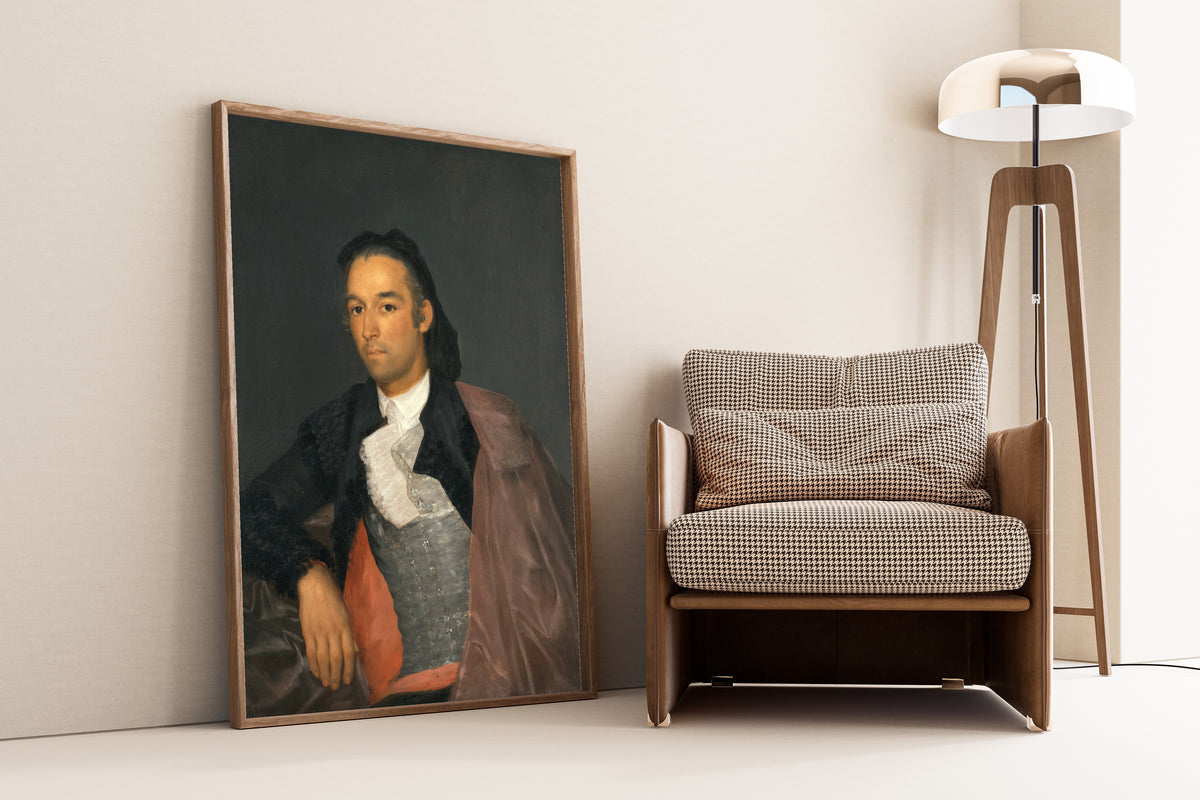 Framed art print of Portrait of the Matador Pedro Romero by Francisco de Goya, leaning against a wall beside an armchair and a floor lamp