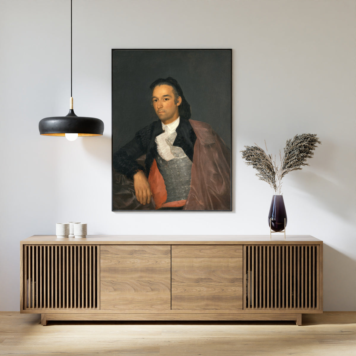 Framed art print of Portrait of the Matador Pedro Romero by Francisco de Goya, above a slatted wood sideboard