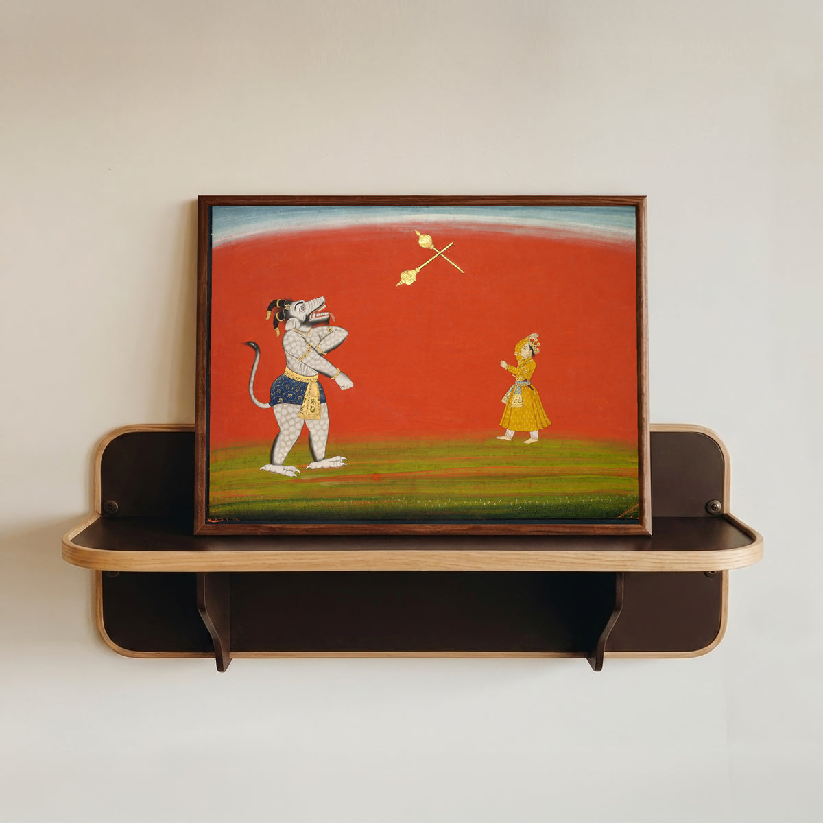 Framed art print of Pradyumna and Samvara Fight with Maces by Pahari school, in a dark wood frame resting on a wall shelf