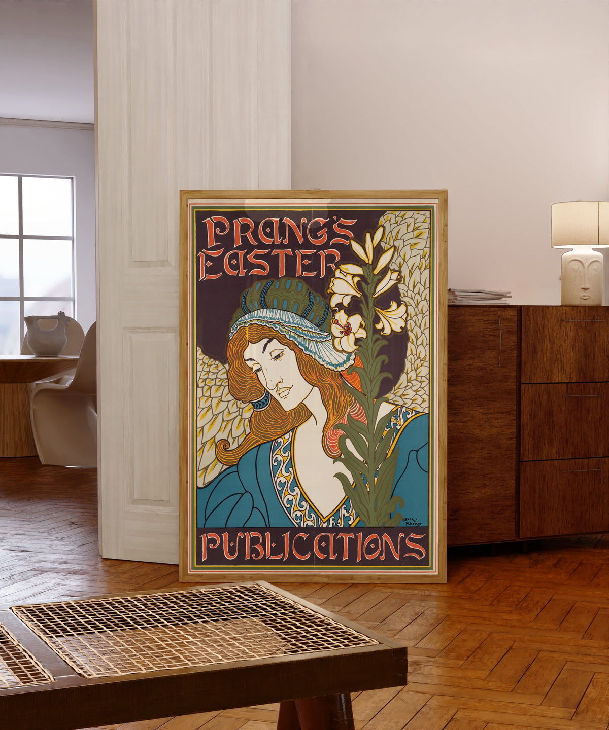 Framed art print of Prang's Easter Publications by Louis Rhead, in a light wood frame leaning in a warm room with a parquet floor