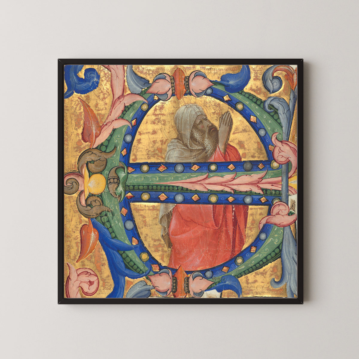 Framed art print of Praying Prophet by Lorenzo Monaco, in a black frame on a pale wall