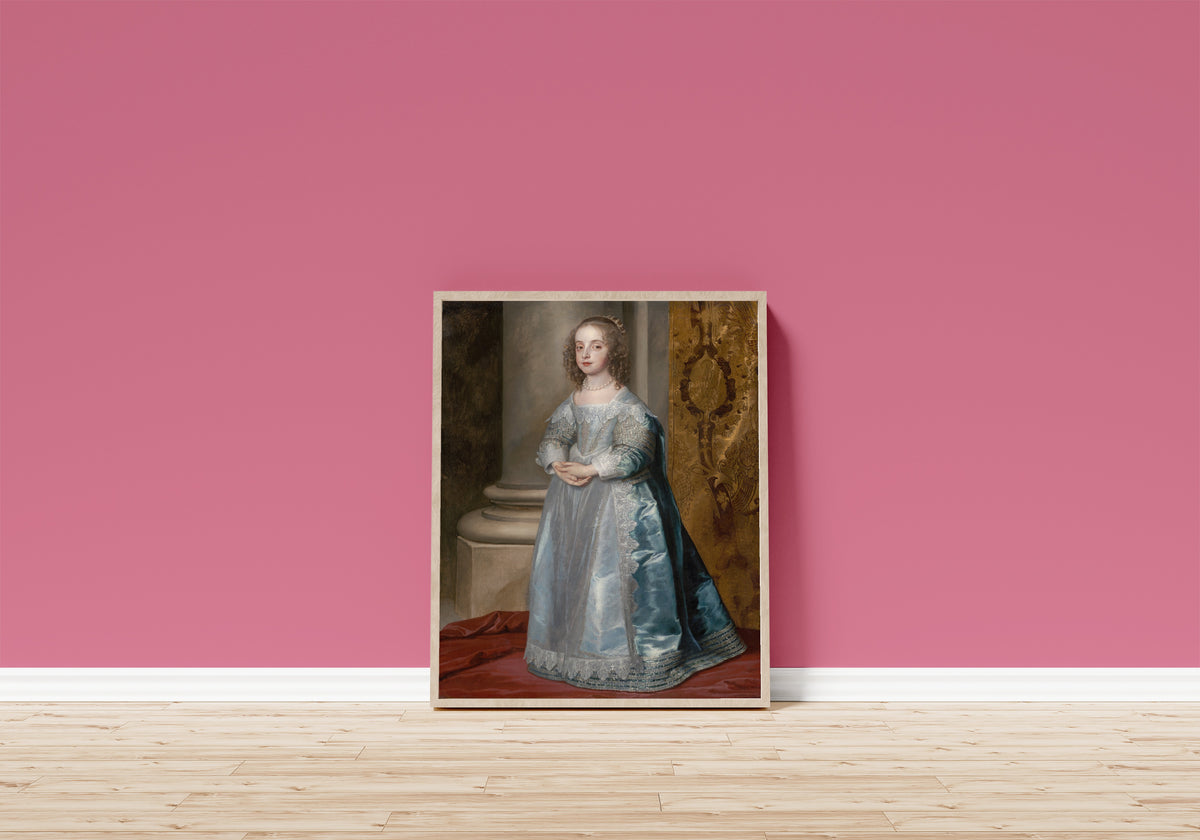Framed art print of Princess Mary, Daughter of Charles I by Anthony van Dyck, in a light wood frame leaning on a pink wall above a wooden floor