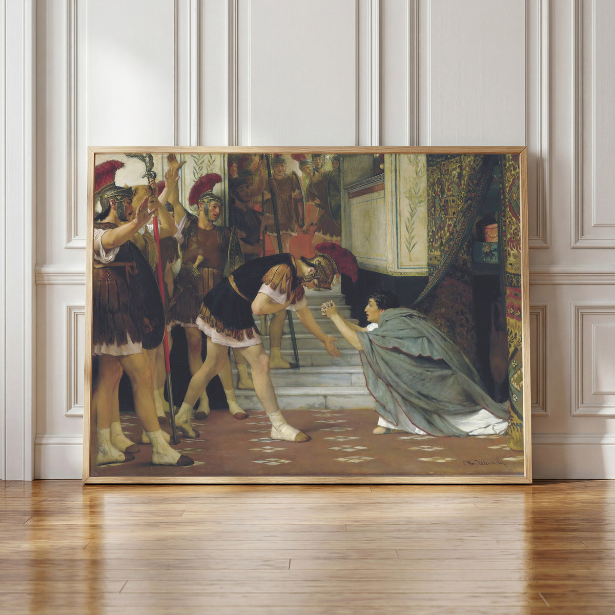 Framed art print of Proclaiming Claudius Emperor by Lawrence Alma-Tadema, in a light wood frame leaning against a panelled white wall