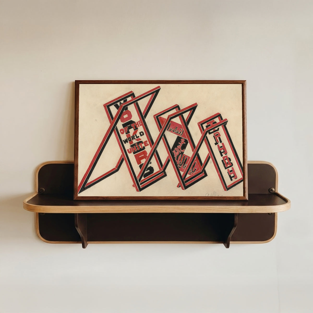 Framed art print of Propaganda stand (Workers of the world unite) by Gustav Klutsis, in a dark wood frame resting on a wall shelf