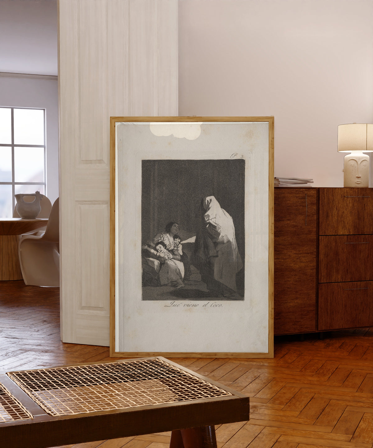 Framed art print of Que viene el Coco (Here Comes the Bogeyman), Los… by Francisco de Goya, in a light wood frame leaning in a warm room with a parquet floor