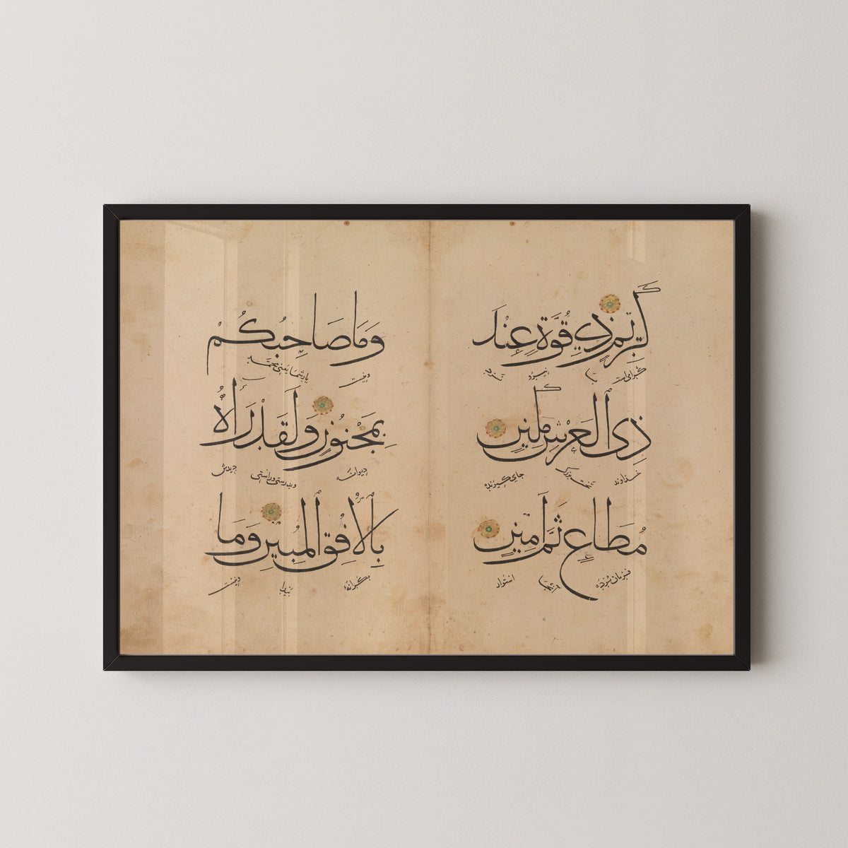 Framed art print of Qur'an Bifolium (Three Lines per Page), in a black frame on a pale wall