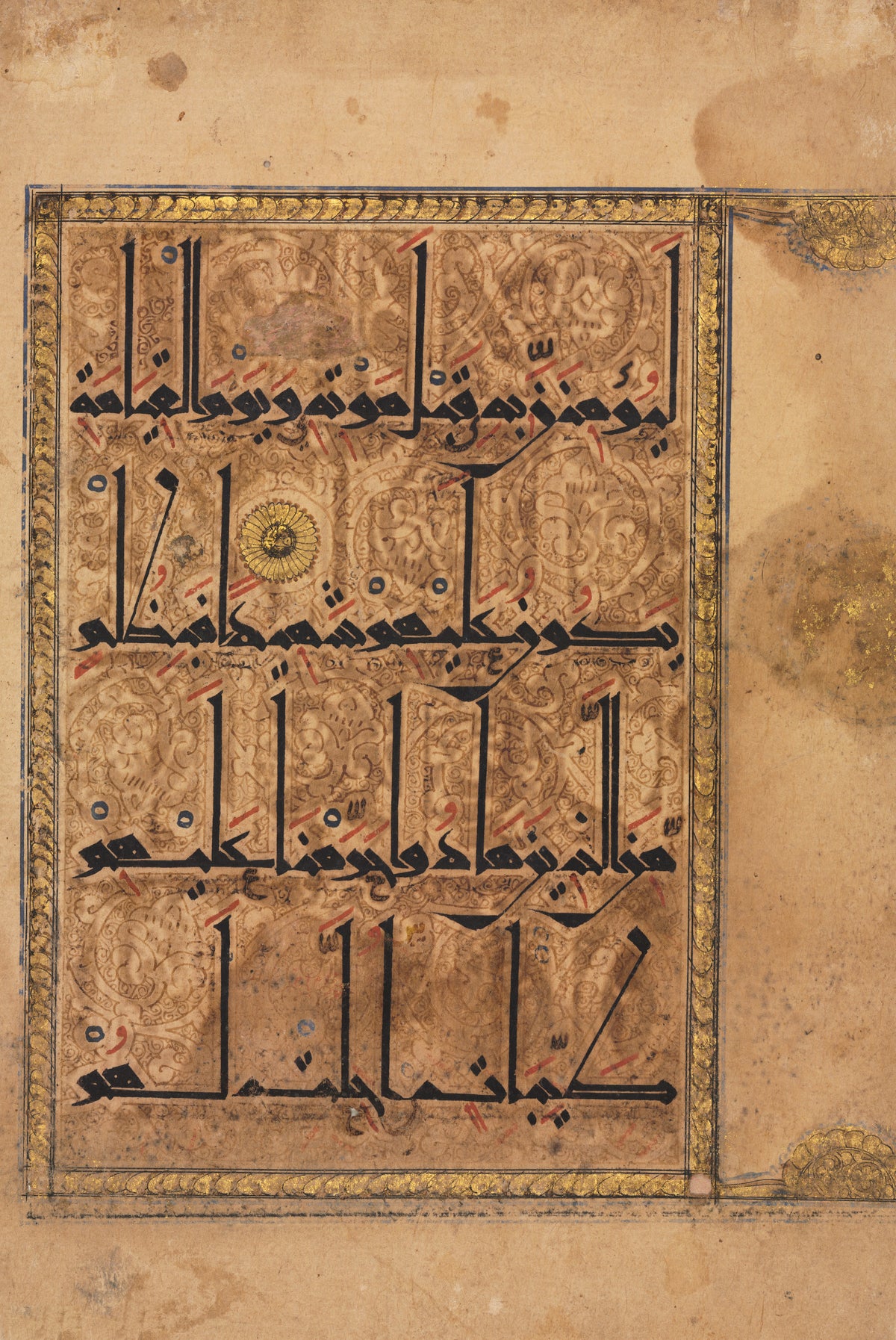 Qur'an Folio: Sura al-Nisa — Four lines of tall eastern Kufic over a ground of fine arabesques