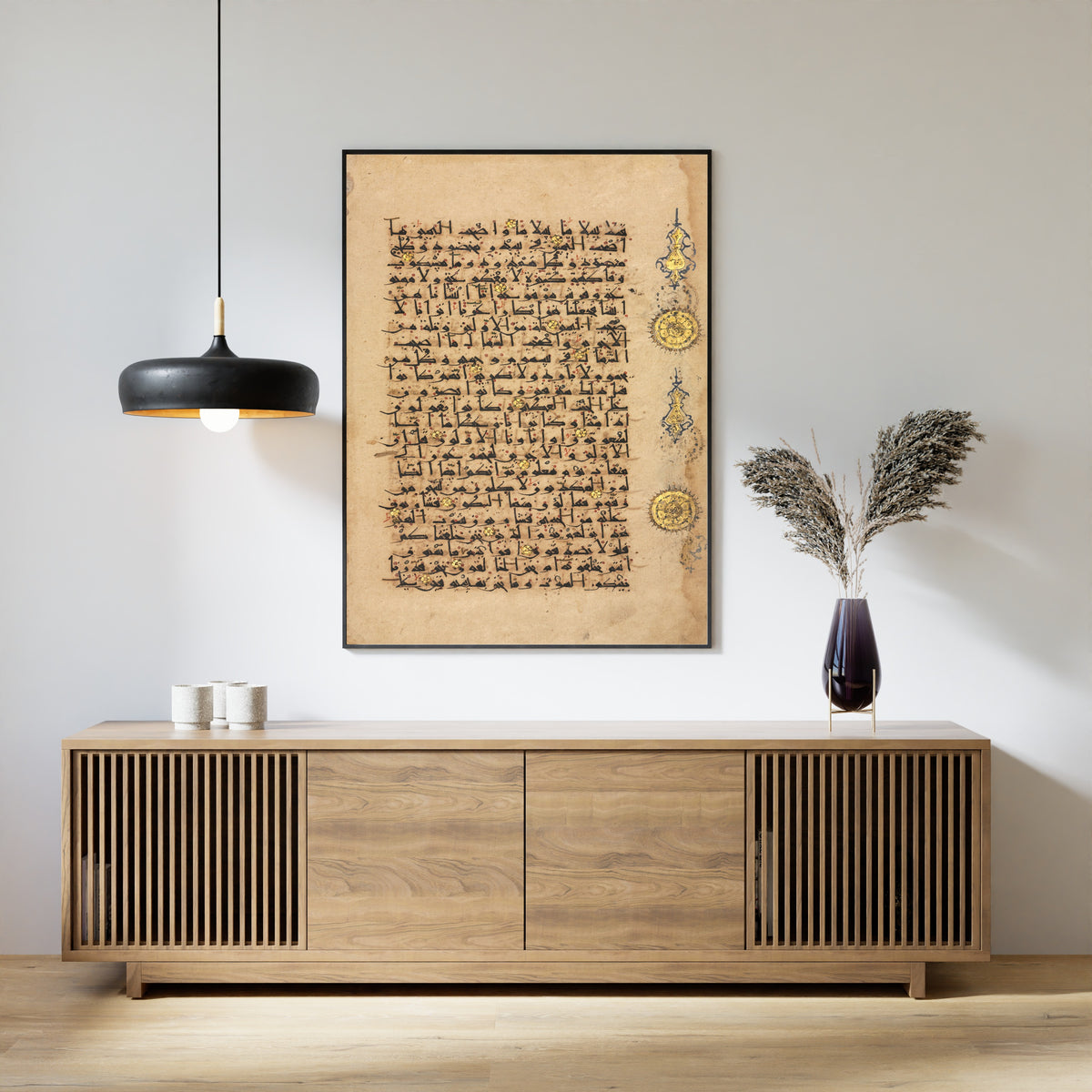 Framed art print of Qur'an Folio: Sura al-Waqi'ah, above a slatted wood sideboard