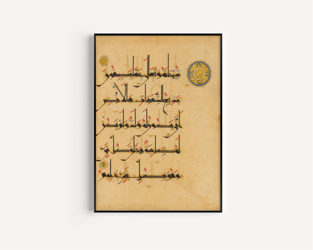 Framed art print of Qur'an Folio (Blue-and-Gold Roundel), in a slim black frame on a plain white wall
