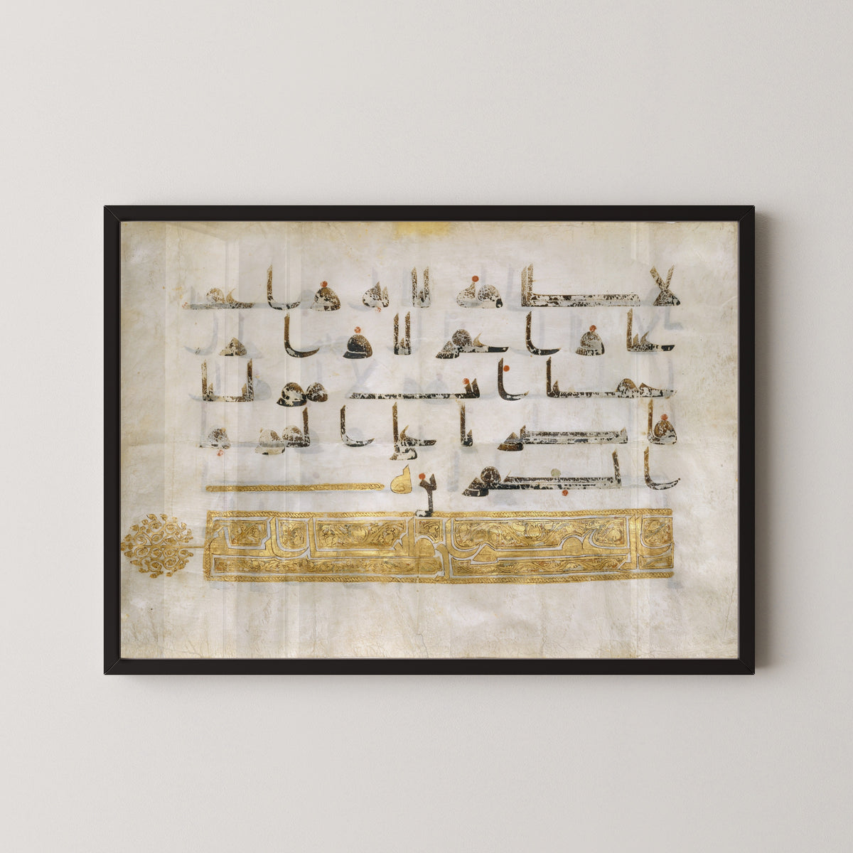 Framed art print of Qur'an Folio (Gold Heading Band), in a black frame on a pale wall