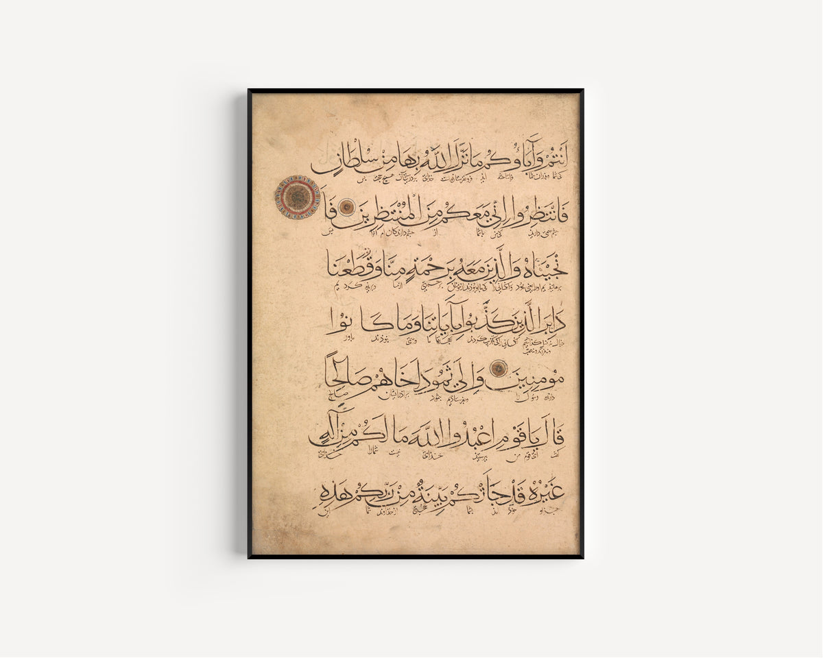 Framed art print of Qur'an Folio (Interlinear Script), in a slim black frame on a plain white wall