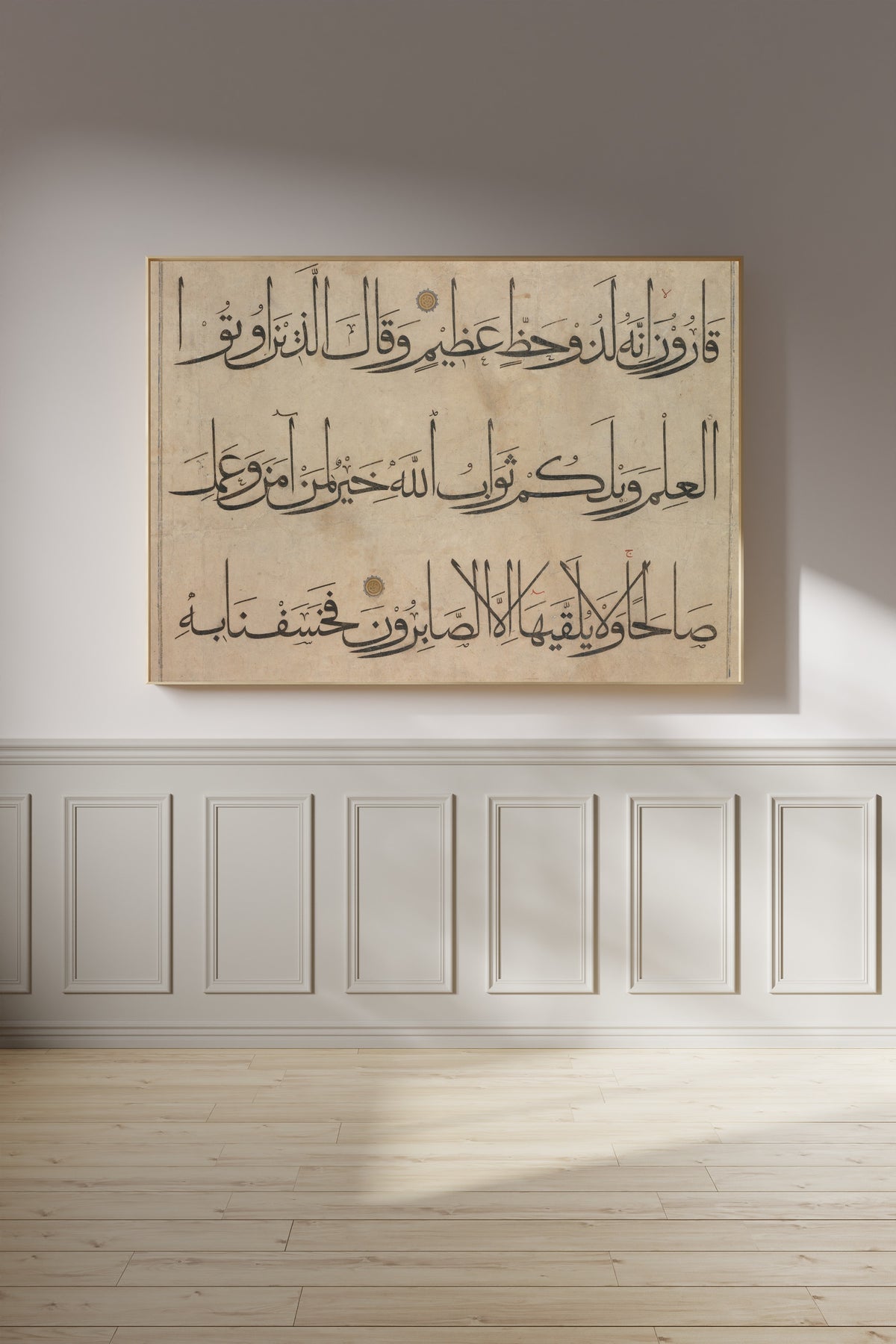 Framed art print of Qur'an Section (Three Lines) by `Umar Aqta', on a panelled wall in afternoon light