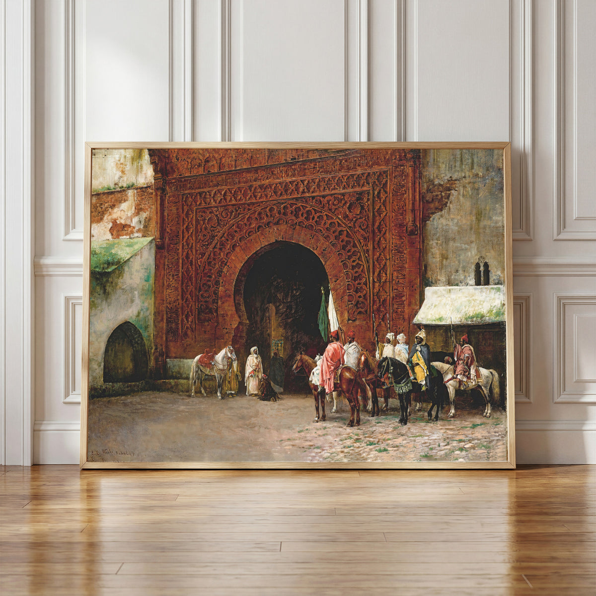 Framed art print of Rabat (The Red Gate) by Edwin Lord Weeks, in a light wood frame leaning against a panelled white wall