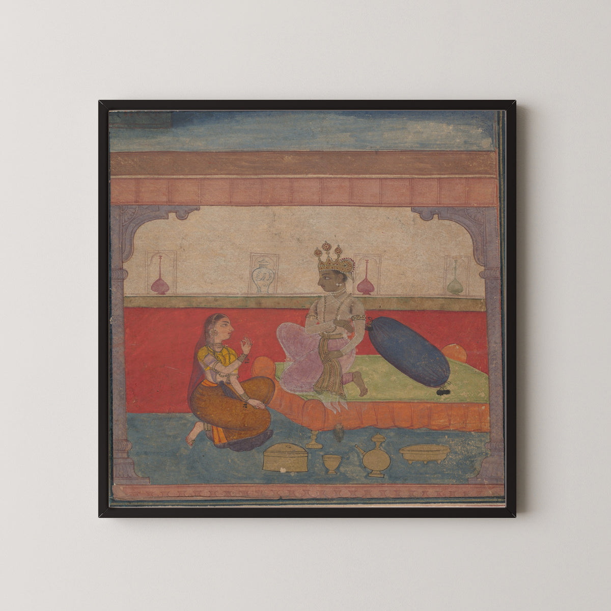 Framed art print of Radha Speaks to Krishna by Amber school, in a black frame on a pale wall