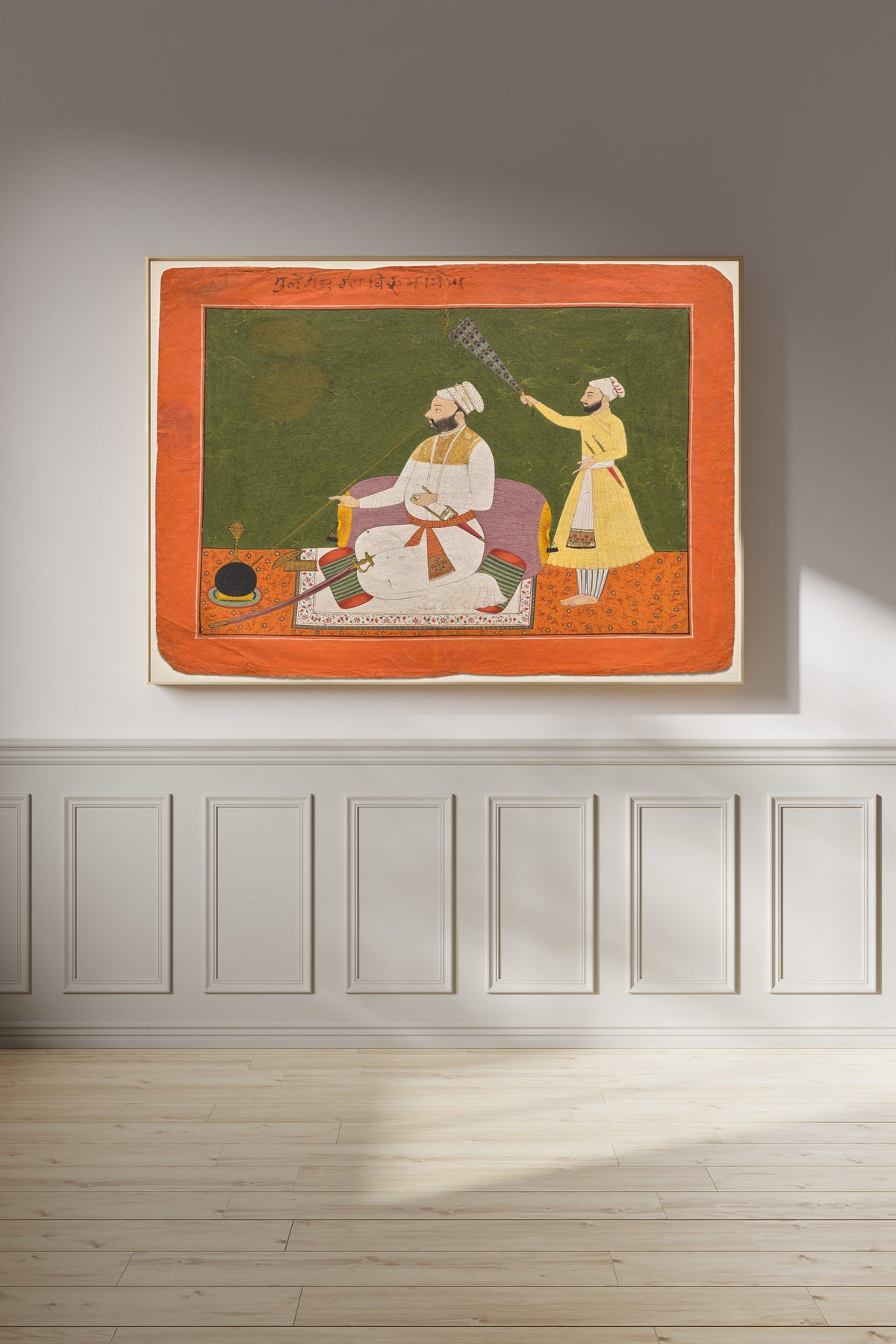 Framed art print of Raja Bikram Singh of Guler Smoking a Hookah by Pahari school, on a panelled wall in afternoon light