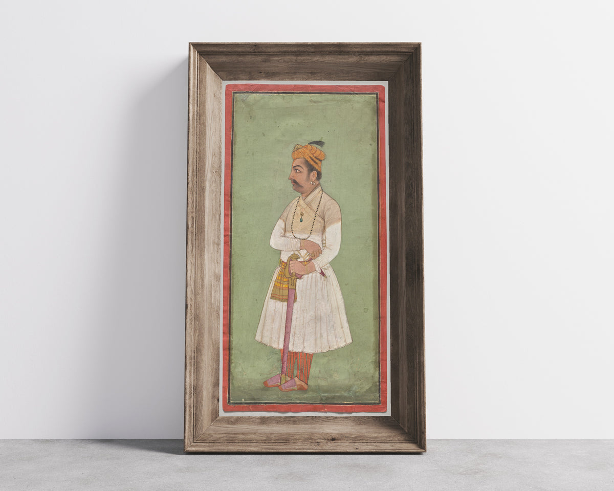 Framed art print of Raja Hari Sen of Mandi by Pahari school, in a wide wooden frame leaning against a concrete wall