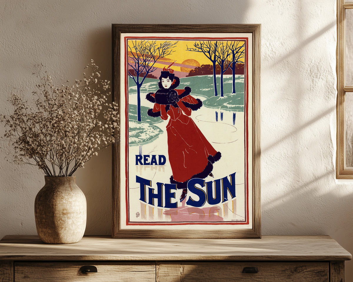 Framed art print of Read The Sun by Louis Rhead, in a dark wood frame leaning on a rustic console beside dried flowers
