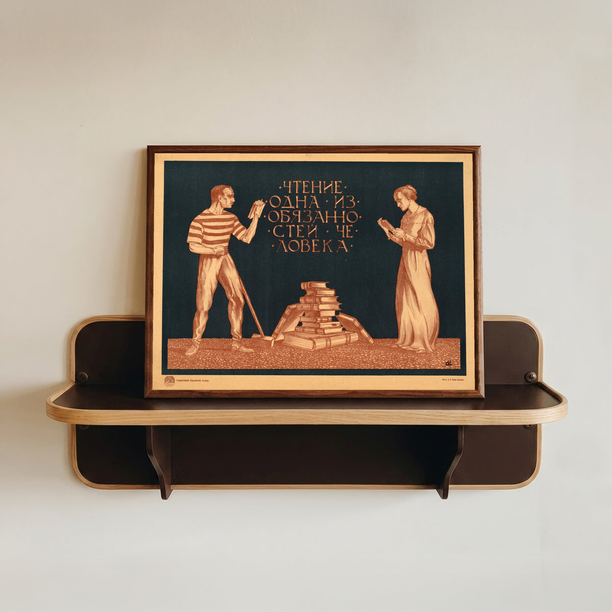 Framed art print of Reading is one of the duties of a person by Sergey Ivanov, in a dark wood frame resting on a wall shelf