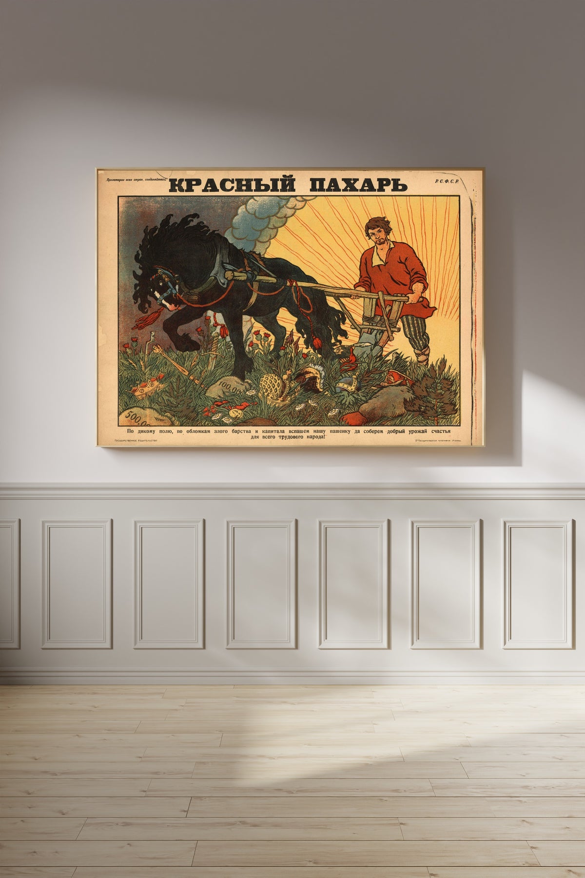 Framed art print of Red Ploughman by Boris Zvorykin, on a panelled wall in afternoon light