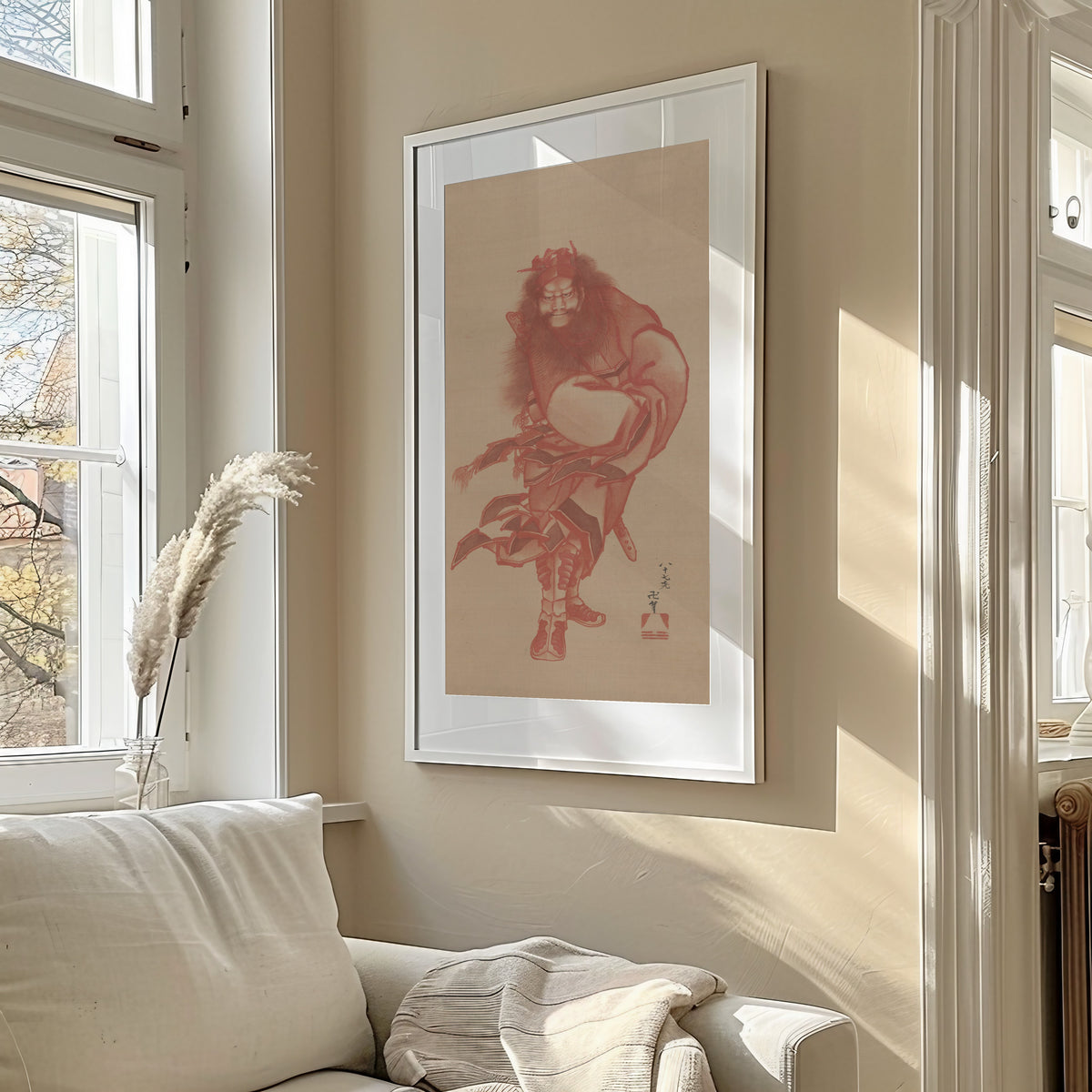 Framed art print of Red Zhong Kui, the Demon Queller by Katsushika Hokusai, in a sunlit living room above a sofa