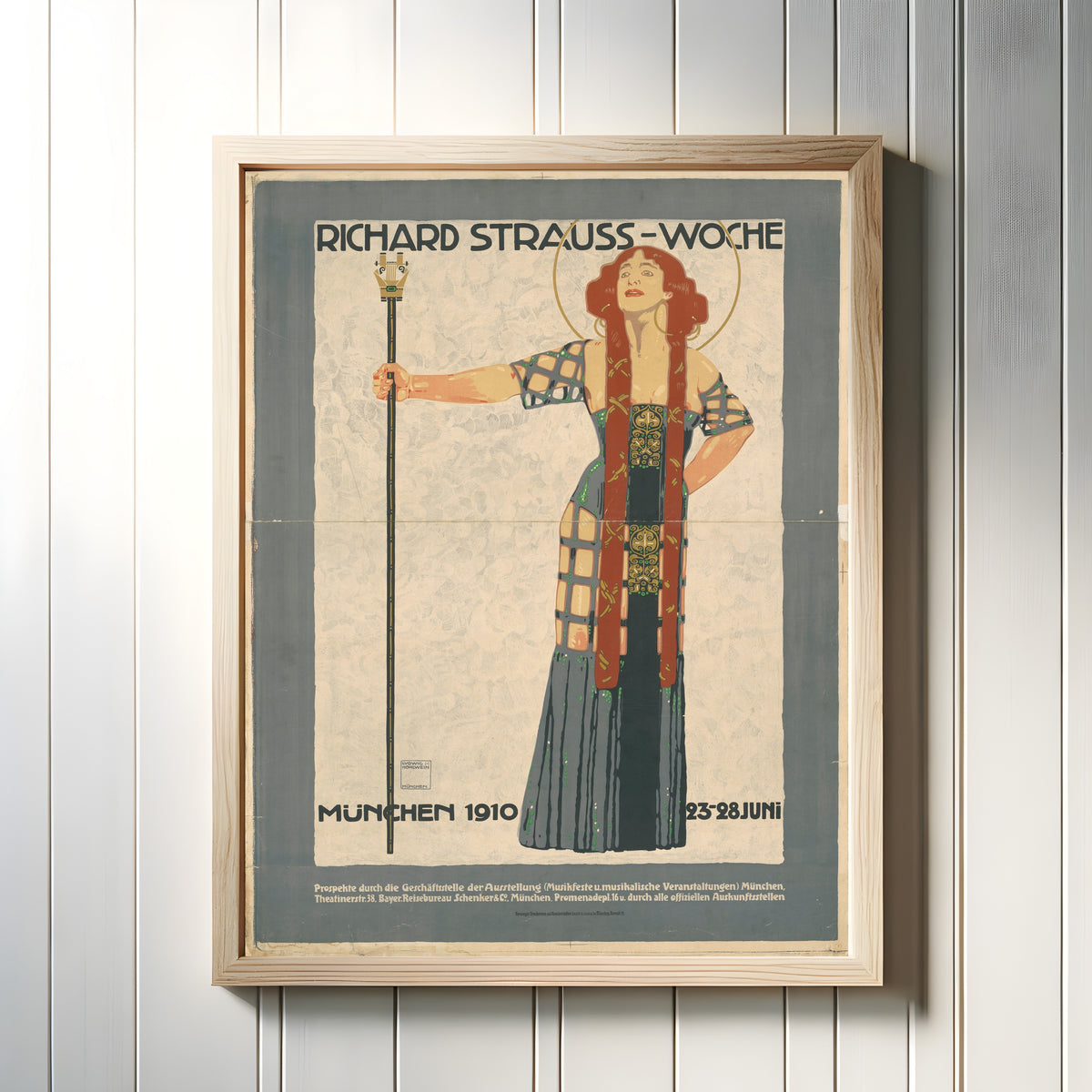 Framed art print of Richard Strauss-Woche, München 1910 by Ludwig Hohlwein, in a light wood frame on a white panelled wall