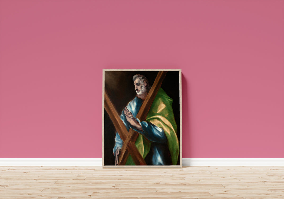 Framed art print of Saint Andrew by El Greco, in a light wood frame leaning on a pink wall above a wooden floor