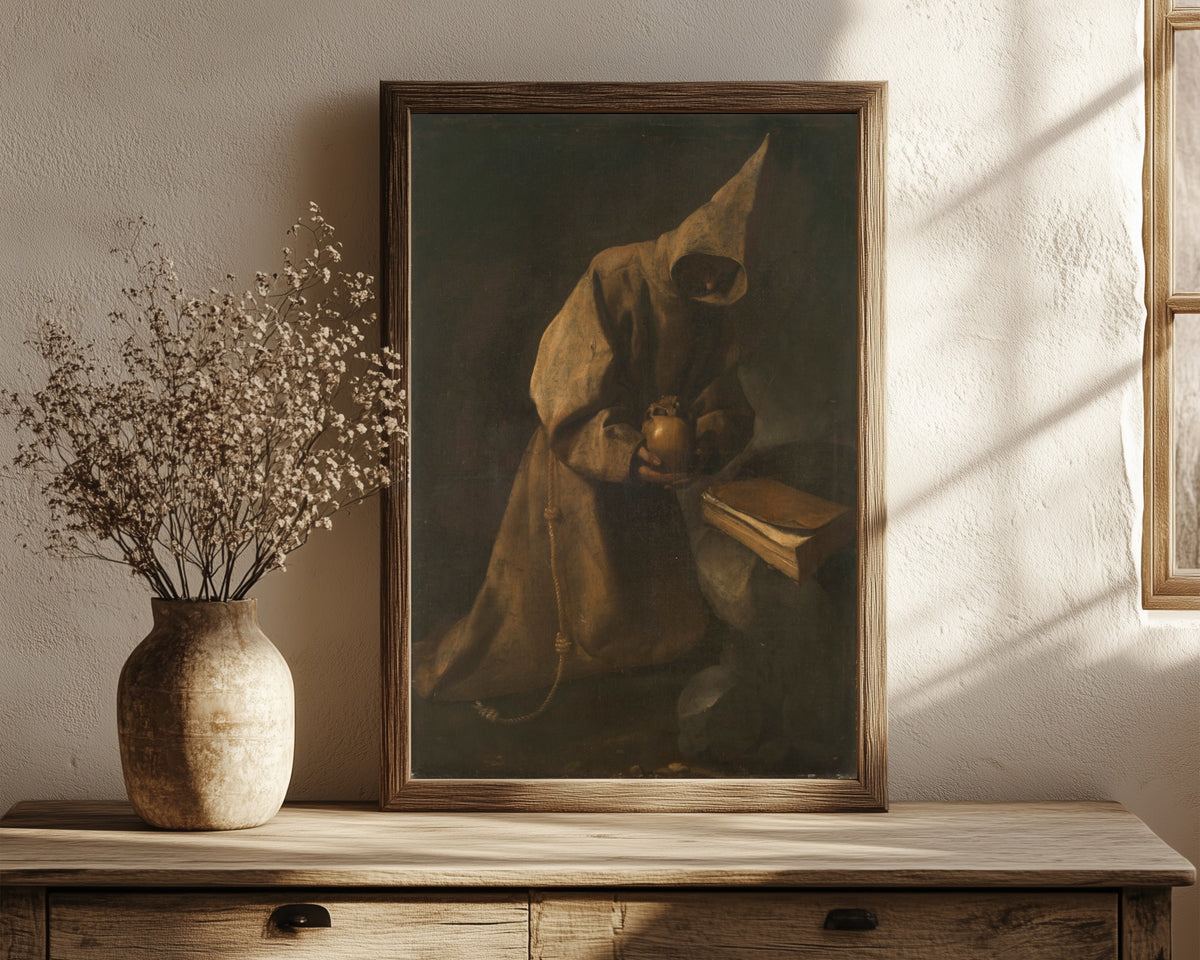 Framed art print of Saint Francis in Meditation by Francisco de Zurbarán, in a dark wood frame leaning on a rustic console beside dried flowers