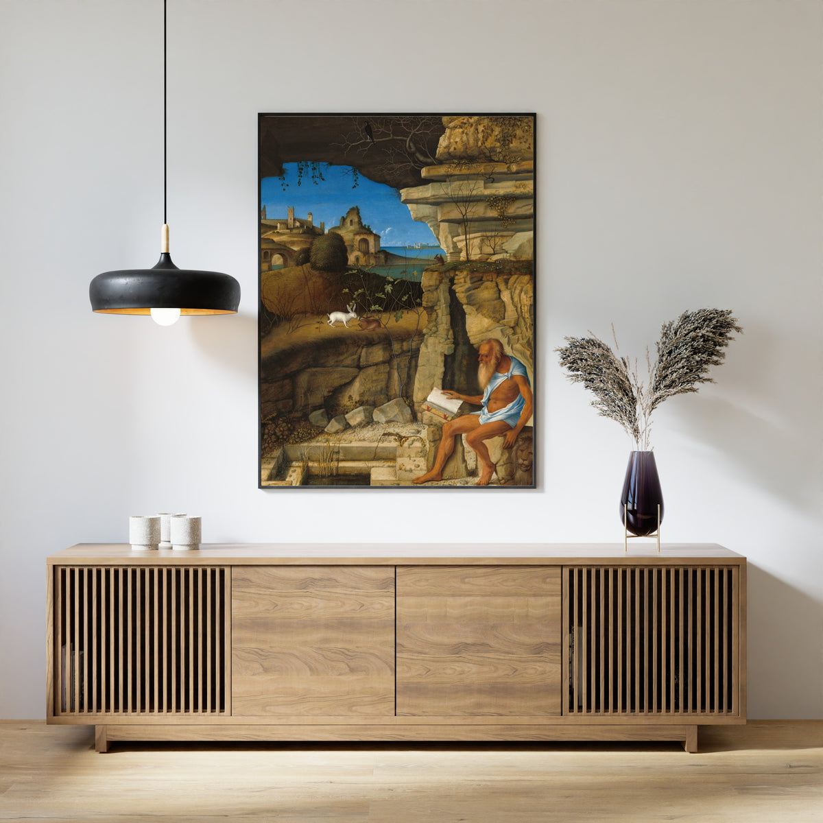 Framed art print of Saint Jerome Reading by Giovanni Bellini, above a slatted wood sideboard