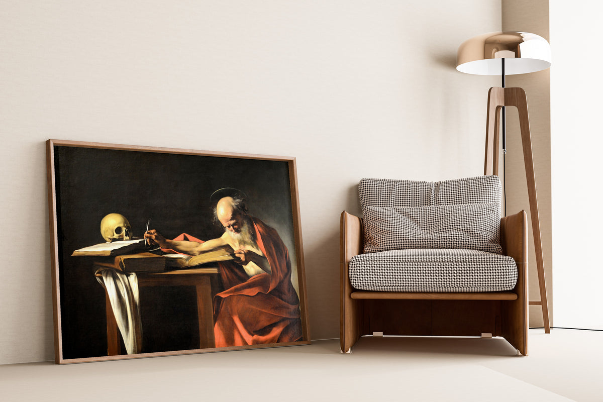 Framed art print of Saint Jerome Writing by Caravaggio, leaning against a wall beside an armchair and a floor lamp