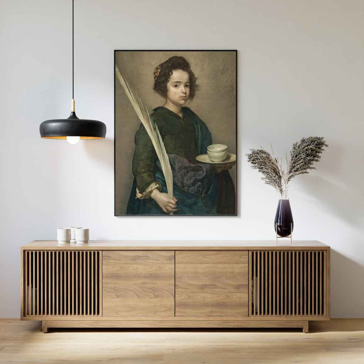 Framed art print of Saint Rufina by Diego Velázquez, above a slatted wood sideboard