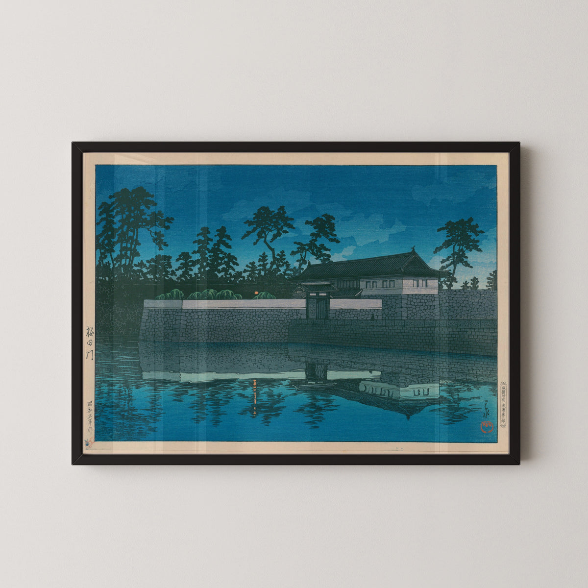 Framed art print of Sakurada Gate by Kawase Hasui, in a black frame on a pale wall