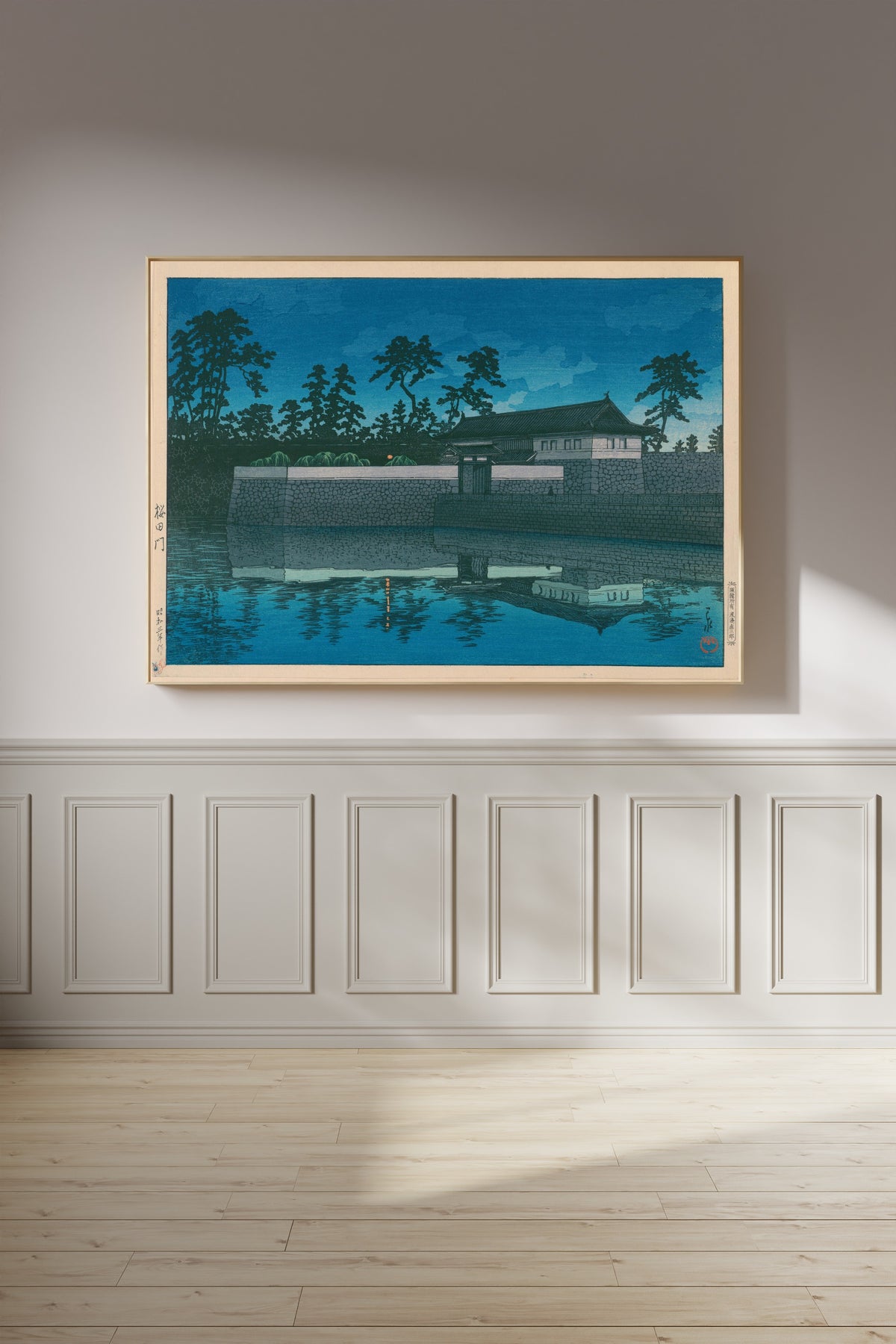 Framed art print of Sakurada Gate by Kawase Hasui, on a panelled wall in afternoon light