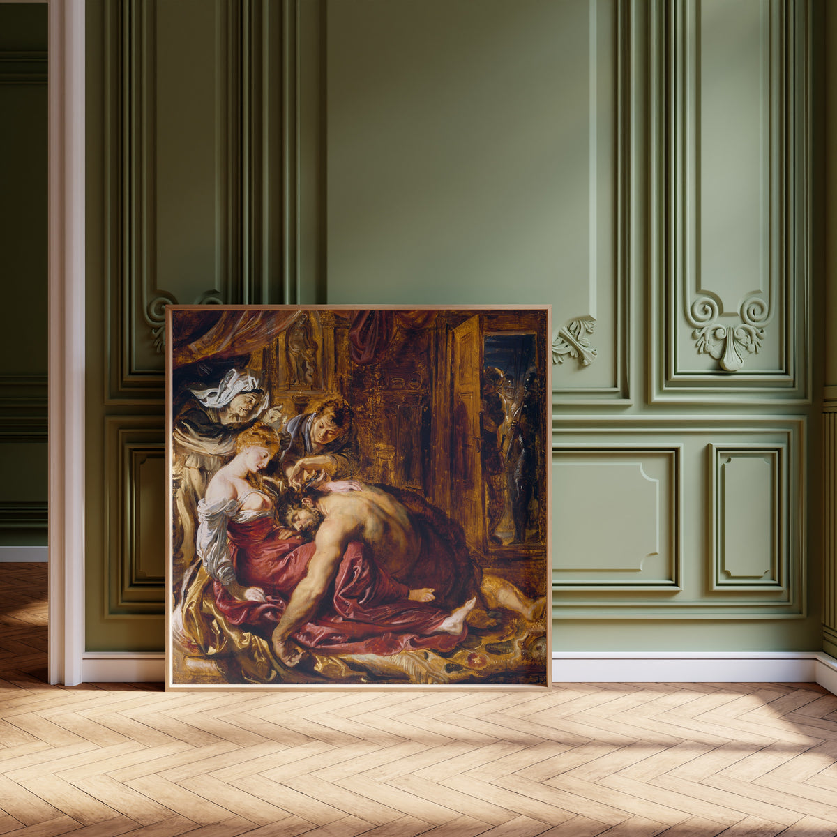 Framed art print of Samson and Delilah by Peter Paul Rubens, leaning against olive-green panelling on a herringbone floor