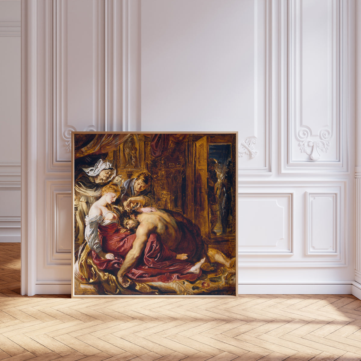 Framed art print of Samson and Delilah by Peter Paul Rubens, leaning against pale pink panelling on a herringbone floor