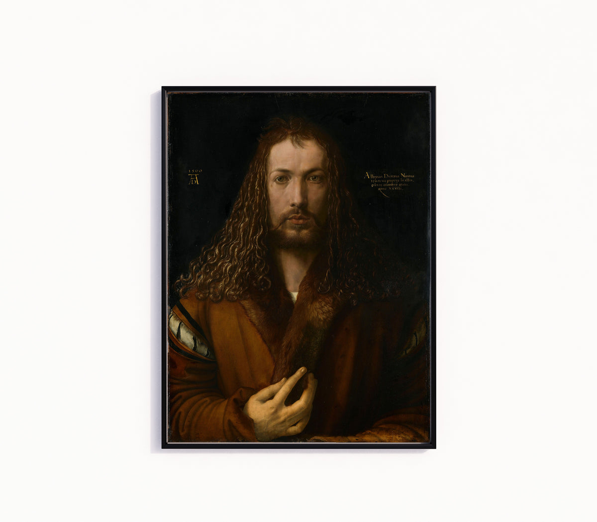 Framed art print of Self-Portrait in a Fur-Trimmed Coat by Albrecht Dürer, in a slim black frame on a plain white wall