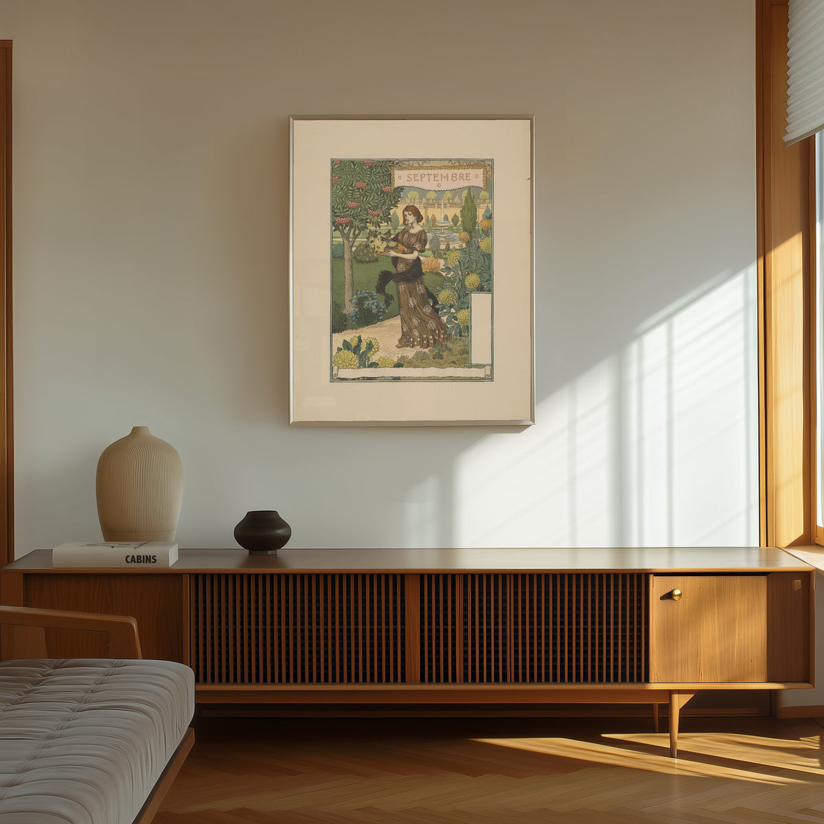 Framed art print of Septembre by Eugène Grasset, in a thin light frame on a sunlit wall above a wooden sideboard